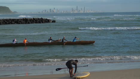 Surfer-Mit-Surfbrett-Und-Paddel---Drachenboot-Paddler-Trainieren-Am-Strand-Von-Currumbin---Gold-Coast,-Queensland,-Australien