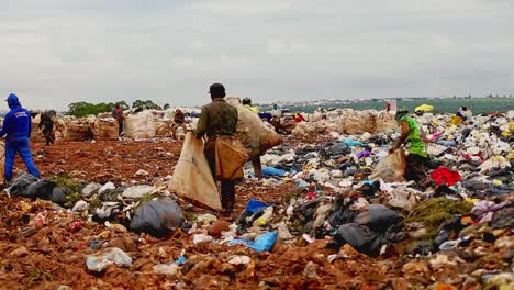 Verarmte-Menschen-Tragen-Große-Säcke-Zum-Füllen,-Während-Sie-In-Einer-Müllhalde-In-Brasilien-Plündern