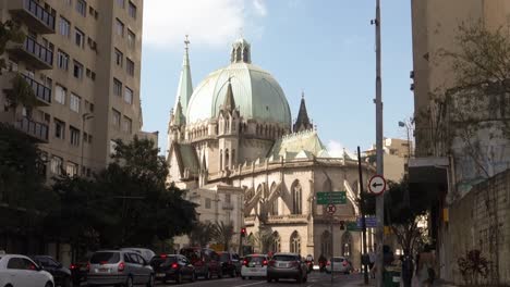 Blick-Auf-Die-Straße-Mit-Fahrzeugen-Und-Menschen-In-Der-Innenstadt-Und-Der-Kathedrale-Im-Hintergrund