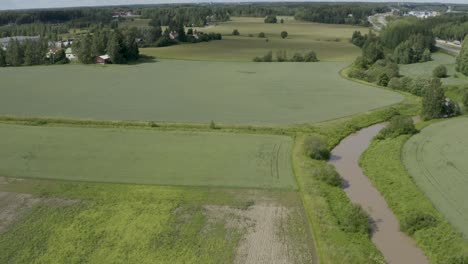 Slow-aerial-view-of-the-Keravanjoki-River-in-Finland-near-Kerava-with-the-countryside-and-motorway-in-the-frame