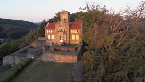 Isenburg-restored-medieval-castle-at-dawn,-aerial-drone-reveal-shot