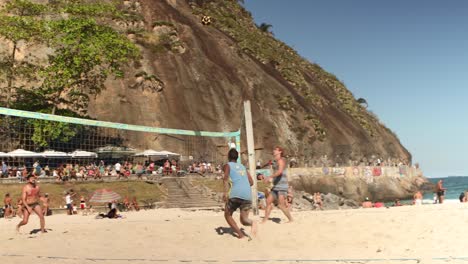 Voleibol-De-Pie-Con-Red-De-Voleibol-Con-Una-Mujer-Y-Dos-Hombres-Jugando-Frente-A-La-Colina-Leme-Al-Final-Del-Bulevar-Copacabana-Y-Quioscos-Al-Borde-De-La-Roca