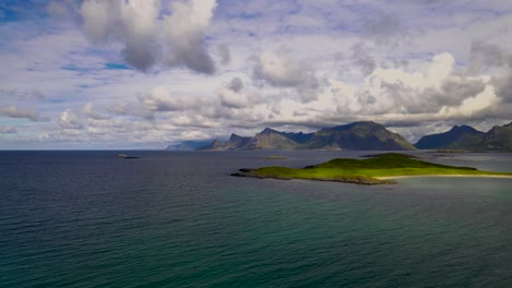 AERIAL:-Green-island-with-majestic-mountains-in-the-background