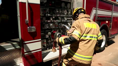 Feuerwehrmann-überprüft-Den-Wasserschlauch-Des-Löschfahrzeugs,-Während-Er-Auf-Einen-Brand-In-Einem-Covid-19-behandlungskrankenhaus-Reagiert