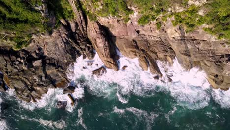 Aerial-top-down-view-of-sea-waves-breaking-on-the-rocky-coastline
