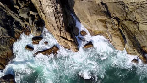 Aerial-top-down-view-of-sea-waves-breaking-on-the-rocky-coastline