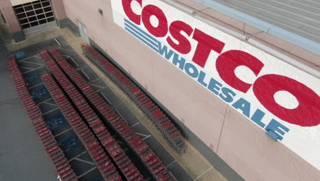 Costco-Wholesale-Club-membership-shopping,-grocery-store,-aerial-reveal-of-logo,-sign,-shopping-carts,-outside-entrance