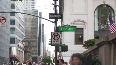 Everyday-Life-on-Streets-of-New-York-and-Manhattan-on-Summer-Day,-Fifth-Avenue-Sign-on-Crossroad-and-People-on-Sidewalk