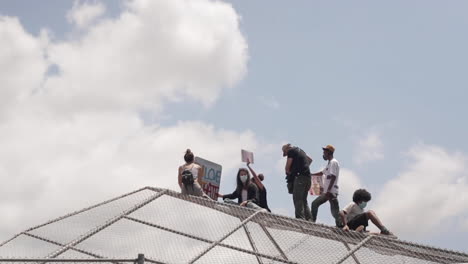 Group-of-Black-Lives-Matter-Protestors-Cheer-From-Top-of-Backstop,-Slow-Motion