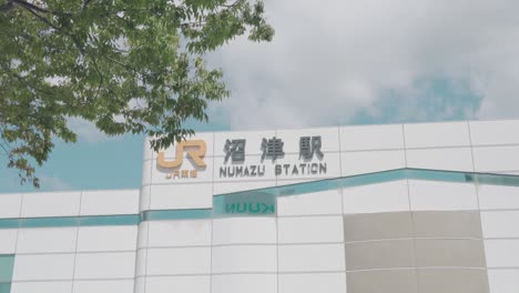 Building-Sign-Of-The-Numazu-JR-Train-Station-In-Numazu,-Japan-On-A-Sunny-Day---low-angle,-static-shot