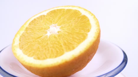 Close-up-fresh-valencia-orange-sliced-with-white-background-shallow-focus-and-slowly-rotating