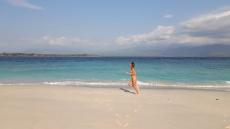 Beautiful-woman-running-at-sandy-beach-of-Gili-Meno-Island