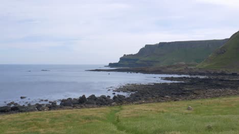 Scenic-Landscape-Of-Coastal-Mountains,-Calm-Ocean,-And-The-Famous-Giant's-Causeway-In-County-Antrim,-Northern-Ireland