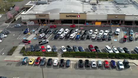 Timelapse-View-Of-The-Busy-Parking-Lot-In-Front-Of-The-Safeway-Grocery---Cars-Driving-And-Moving-Around-The-Parking-Lot-To-Find-Empty-Space-In-Tacoma,-Washinton,-USA