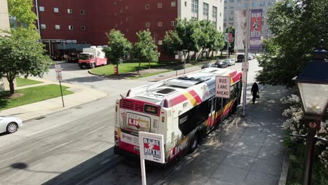 Establishing-shot-in-downtown-Baltimore,-near-Babe-Ruth-birthplace-and-museum,-University-of-Maryland-Hospital-entrance,-city-transit-parked-in-bus-lane