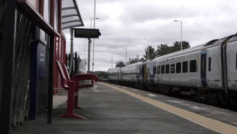 Train-traveling-through-railway-station-wide-tilting-shot
