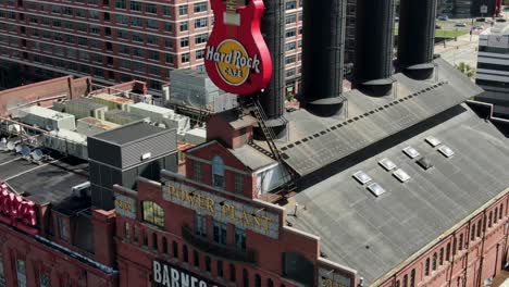 Descending-aerial,-Hard-Rock-Cafe-at-Power-Plant-in-Baltimore,-Barnes---Noble-Bookstore,-Inner-Harbor,-smokestacks