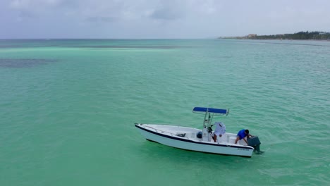 Dos-Hombres-Salen-En-Un-Pequeño-Bote-De-Pesca-Blanco-A-Las-Hermosas-Aguas-Turquesas-Del-Océano-Dominicano