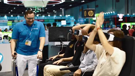 Virtual-Reality-Demonstration---People-Sitting-And-Experiencing-VR-Roller-Coaster-Inside-A-Mall---medium-shot