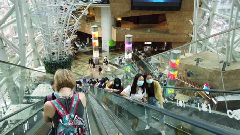 People-using-an-escalator-in-Hong-Kong-Langham-place,-a-unique-commercial-and-shopping-complex-in-Kowloon-area