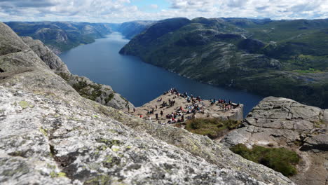 Tourist-group-on-Pulpit-Rock-cliff-above-fjord-in-Norway-after-hike