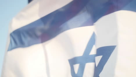 Flag-of-Israel-Flying-High-with-American-Flag-Behind-in-the-Background,-Slow-Motion