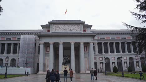 Turistas-Paseando-Y-Tomando-Fotos-De-La-Estatua-De-Bronce-De-Diego-Velazquez-Frente-Al-Museo-Del-Prado-Ubicado-En-El-Paseo-Del-Prado-En-Madrid,-España---Tiro-Inclinado