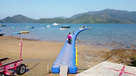 Einheimische-Gehen-An-Einem-Sommertag-Auf-Einem-Kleinen-Pier-In-Hongkong-Mit-Kleinen-Booten-Im-Wasser