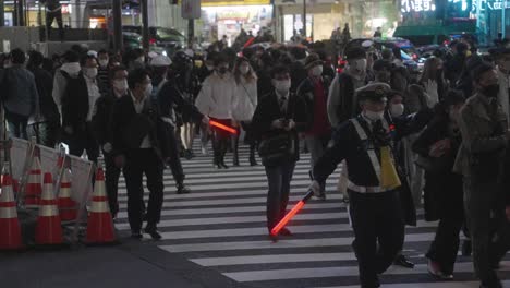 Policías-Enmascarados-Controlando-A-La-Multitud-En-El-Cruce-De-Shibuya-En-La-Noche-De-Halloween-En-Tokio,-Japón-Durante-La-Pandemia---Cámara-Lenta
