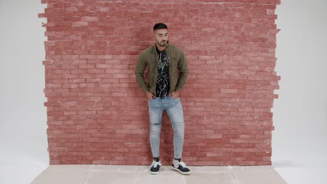 Casual-Man-Walks-Into-Red-Brick-Wall-Frame-Poses-And-Walks-Off---Full-Shot