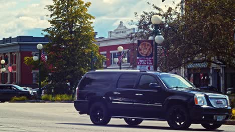 Black-SUV-Driving-On-The-Road-In-Newport,-New-Hampshire,-USA---wide-shot