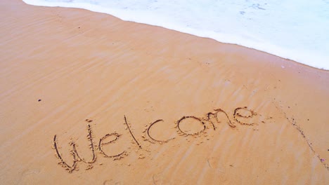Text-Welcome-on-the-sea-beach-and-splashing-waves-on-the-sand-with-the-slow-motion-wave-in-nature-concept