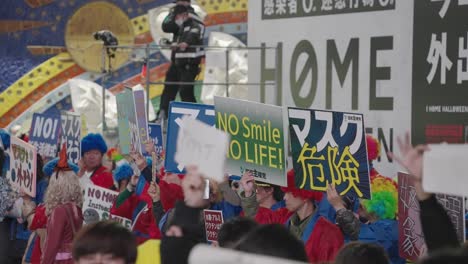 Japoneses-Sosteniendo-Pancartas-Para-Protestar-Contra-El-Uso-De-Máscaras-En-La-Noche-De-Halloween-En-Shibuya---Halloween-2020-En-Tokio,-Japón---Primer-Plano,-Cámara-Lenta