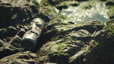 Empty-beer-can-on-rock,-environmental-pollution-concept