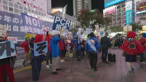 Japoneses-Protestando-Contra-El-Uso-De-Máscaras-Y-Pruebas-Pcr-En-Shibuya-En-La-Noche-De-Halloween---Protesta-Por-Coronavirus-En-Tokio,-Japón---Toma-De-Vista-Lateral