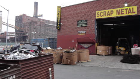 Chatarra-Industrial-De-Brooklyn,-Motociclista-Pasa,-Empleado-Del-Operador-De-La-Carretilla-Elevadora,-Fábrica-De-Azúcar-Domino-En-Segundo-Plano