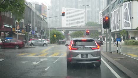 The-view-from-inside-the-car,-the-atmosphere-of-heavy-rain-at-the-intersection-of-traffic-light