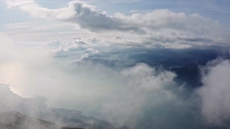 Garda-lake-shines-behind-smoky-clouds-in-morning-mist,-Italian-beauties,-aerial