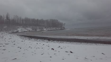 North-Shore-Minnesota-beach-shoreline-during-winter-time,-beach-covered-in-snow