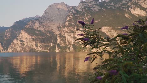 Majestic-mountains-mirrored-in-calm-water-of-Lake-Garda,-quiet-morning-scenery