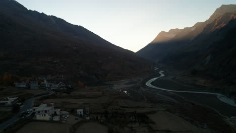 Cold-autumn-morning-aerial-from-a-small,-peaceful-mountain-village-overlooking-a-glacier