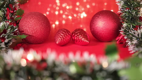 Christmas-decoration-lights,-pine-and-ball-on-red-background