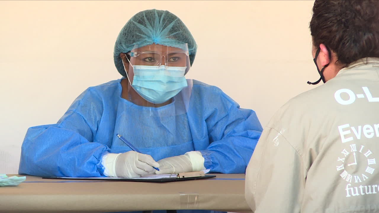 Female Doctor Wearing Full Anticovid Suit While Questioning A Patient ...