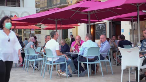 Grupos-De-Personas-Sin-Máscara-Charlando-Mientras-Toman-Una-Copa-En-Una-Cafetería-En-La-Plaza-De-La-Merced,-Málaga,-España---Tiro-Completo