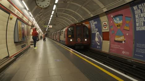 London-underground-train-with-remembrance-poppy-stopping-at-almost-empty-bethnal-green-station