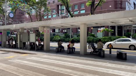 Gente-Esperando-En-La-Parada-De-Autobús,-Orchard-Road,-Singapur