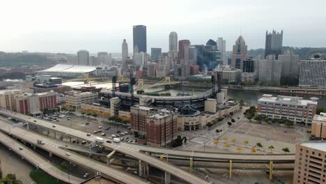Aerial-of-Pittsburgh-PA-urban-city-skyscrapers-and-skyline-with-PNC-Park,-hotels-and-North-Shore-sports-complexes,-bridges-across-Allegheny-River