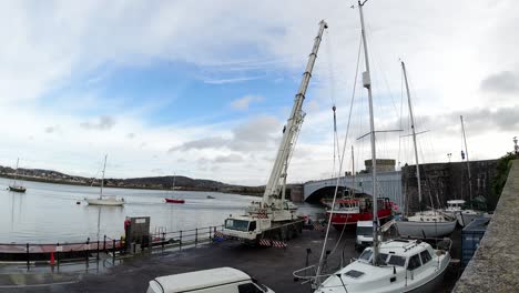 Hydraulic-crane-vehicle-lifting-fishing-boat-vessel-into-Conwy-harbour-timelapse