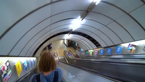 Blonde-Frau,-Die-Auf-Der-Rolltreppe-In-Der-Londoner-U-Bahn-Hinuntergeht