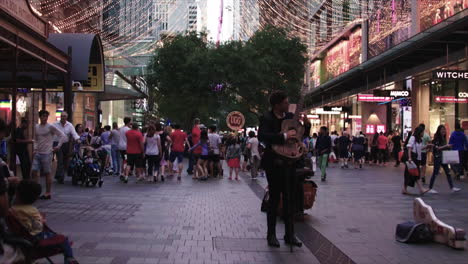 A-guitar-playing-street-performer-plays-for-people-in-the-downtown-street-of-Sydney-decorated-for-the-holidays